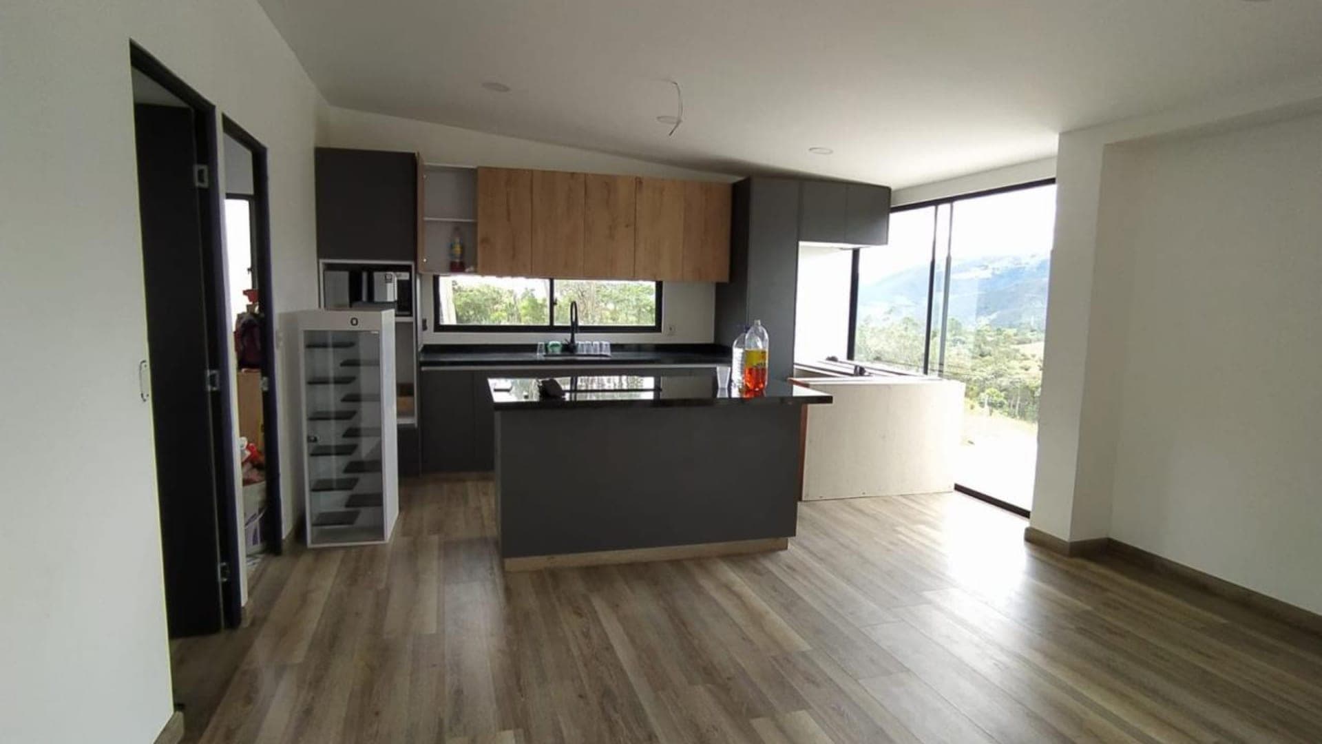 Cocina integral con muebles altos en madera, mesón e isla central